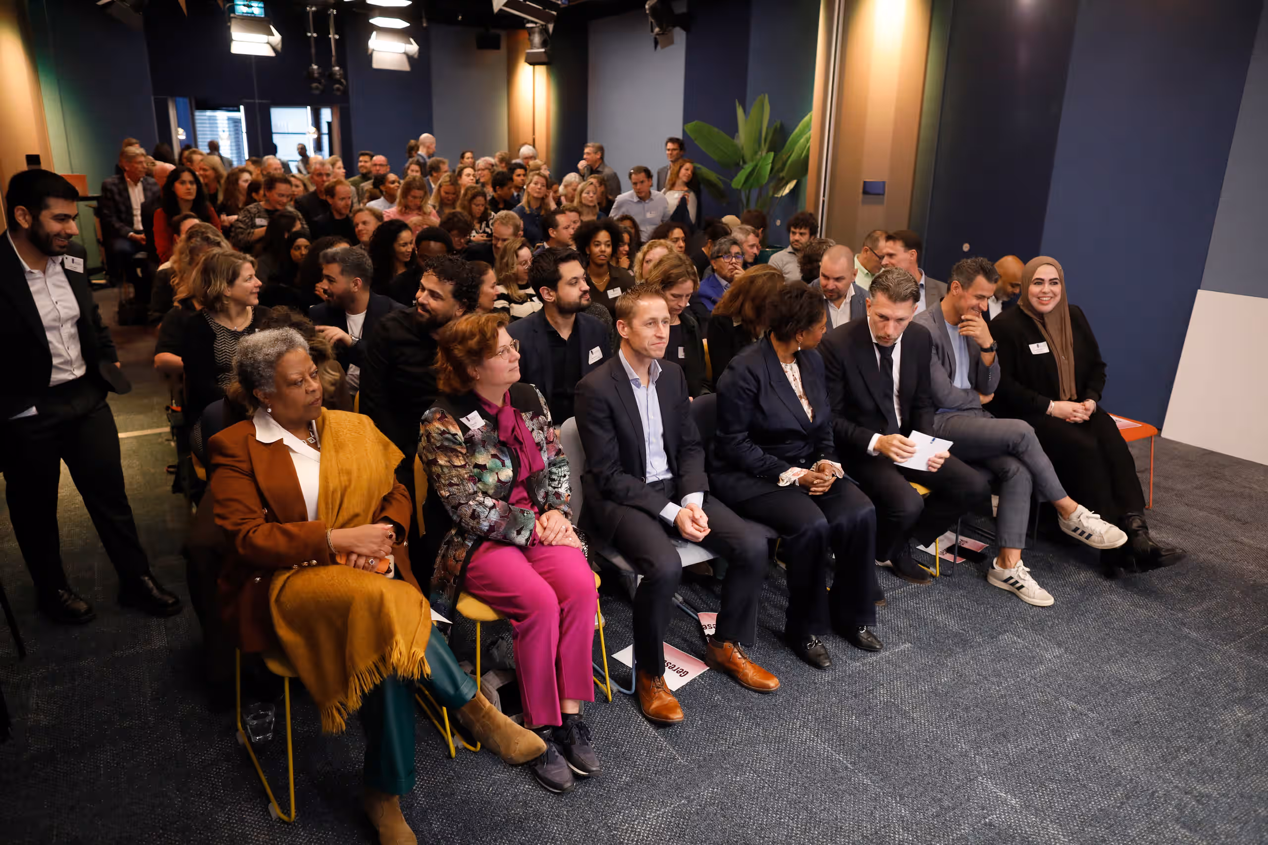In de zaal zitten ruim 100 bezoekers.
